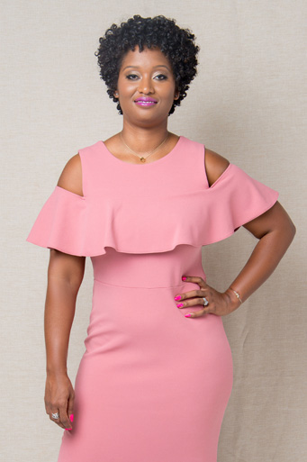 Lorraine Kamesha standing confidently in a ruffled pink dress