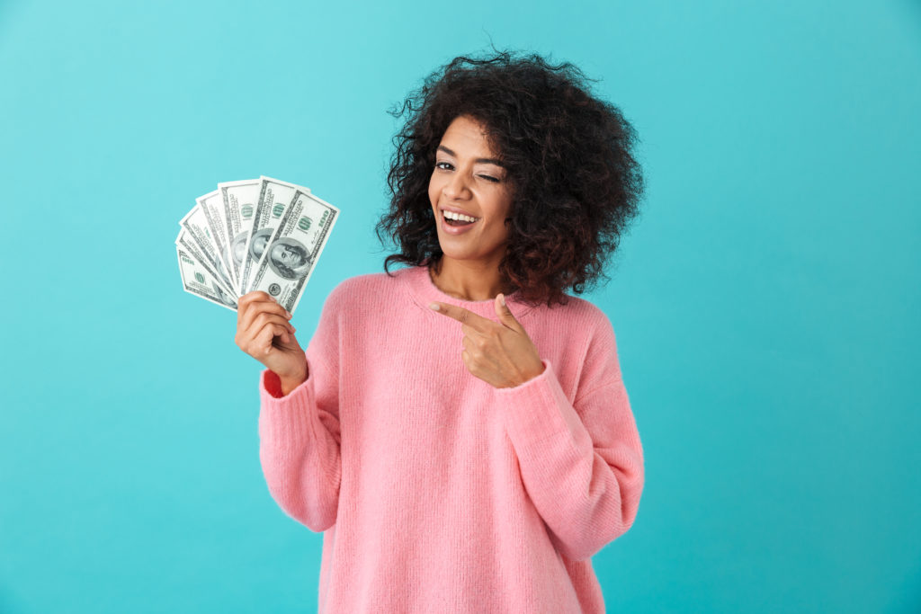happy woman holding cash and smiling