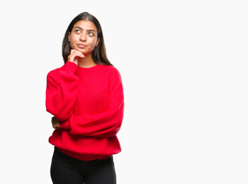 young woman in red sweater considering