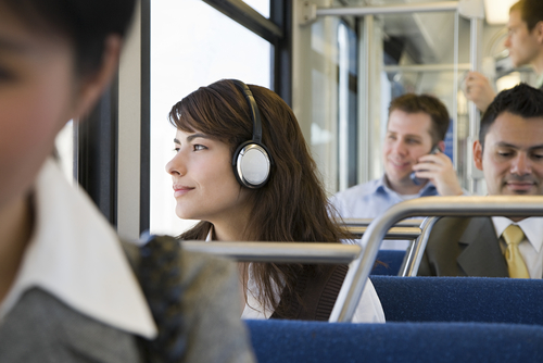 Woman listening to headphones on a commute